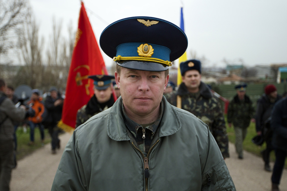 Col. Yuri Mamchur, commander of the Ukrainian garrison at the Belbek airbase, leads his men to the base outside Sevastopol, Ukraine, Tuesday. Russian troops, who had taken control over Belbek airbase, fired warning shots in the air as around 300 Ukrainian officers marched toward them to demand their jobs back.
