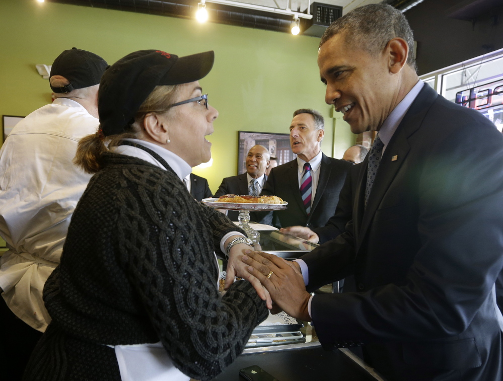 President Obama greets Café Beauregard owner Alice Bruno during his unannounced visit to the café in New Britain, Conn., on Wednesday. Also at the counter with Obama are Massachusetts Gov. Deval Patrick, center, and Vermont Gov. Peter Shumlin.