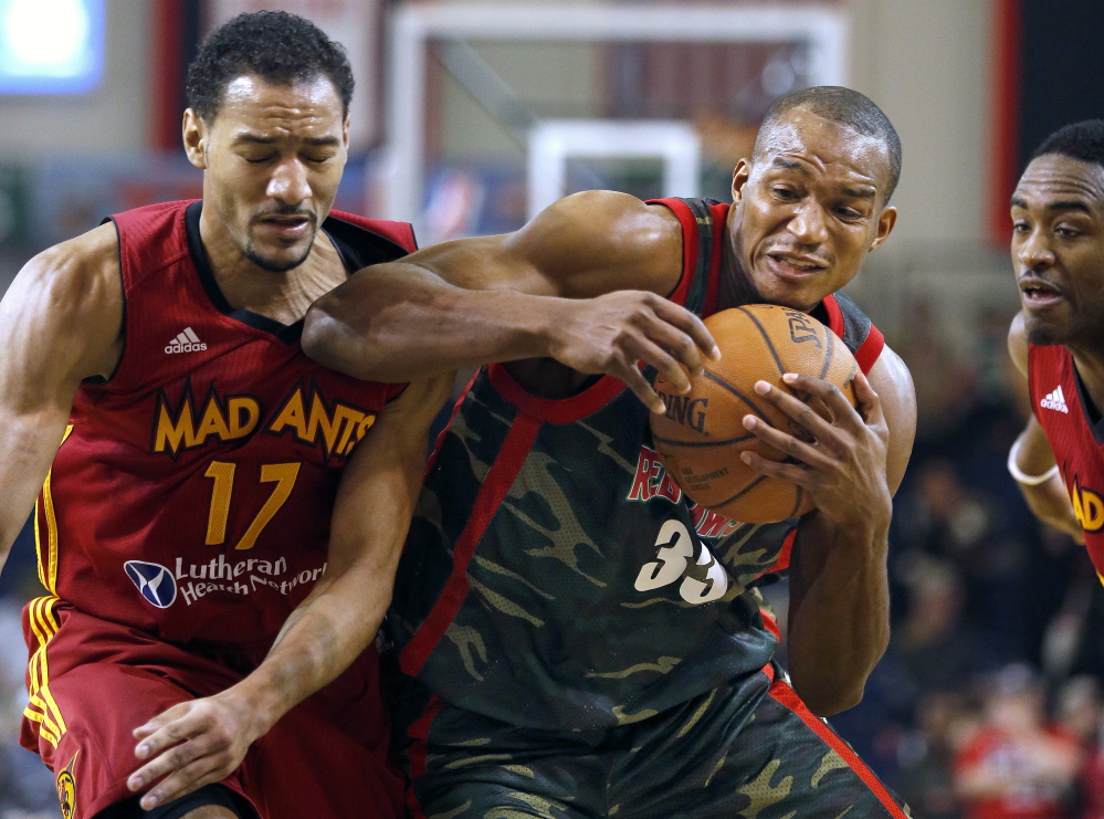 Chris Wright of the Maine Red Claws, center, powers his way past Fort Wayne defenders Sadiel Rojas, left, and Jamaal Franklin, right, Thursday at the Portland Expo. The Red Claws were wearing camoflage uniforms in honor of military appreciation day.