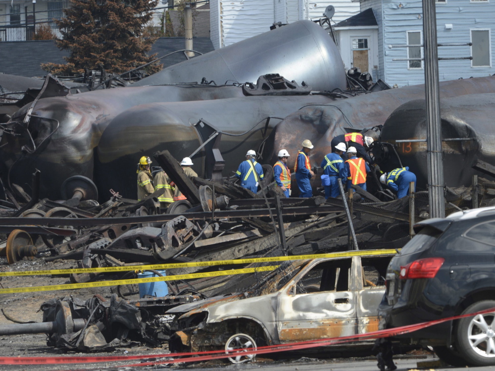 Emergency workers examine the aftermath of a train derailment and fire in Lac-Megantic, Quebec, in July. The Transportation Safety Board of Canada has released its analysis of the train’s cargo.