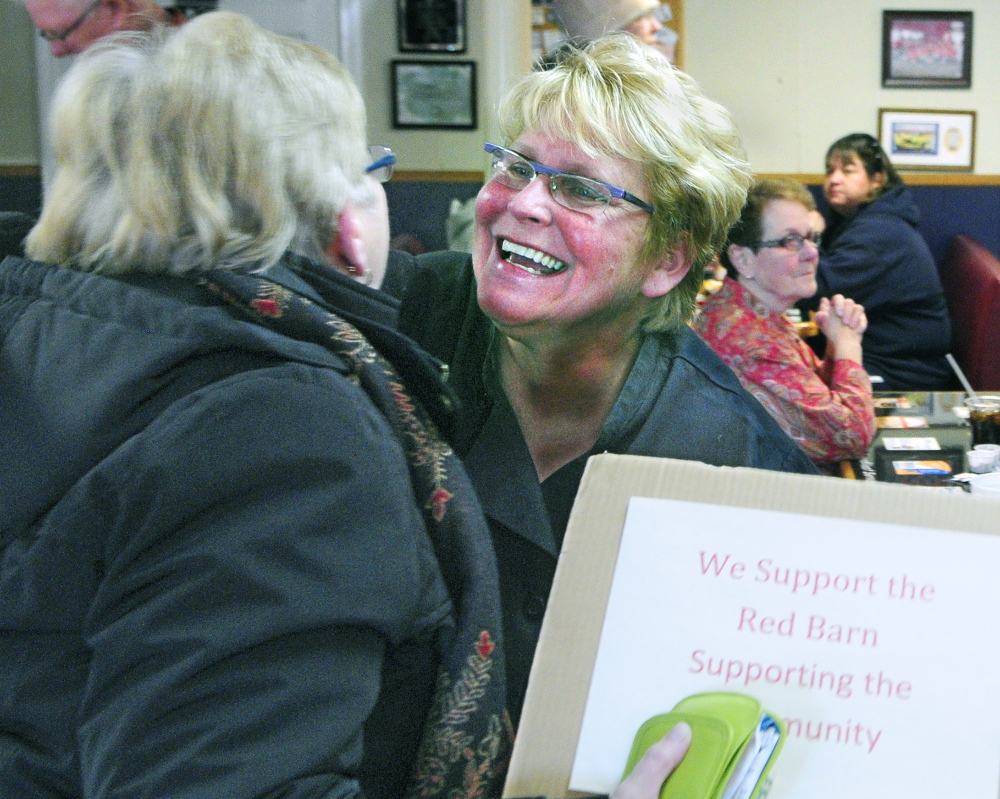 Red Barn owner Laura Benedict, right, hugs Carol Foreman of South China, who brought a sign supporting The Red Barn after the state attorney general notified the restaurant that it was violating state law. A bill heard Thursday would make it easier for small businesses to legally conduct fundraisers for charities.