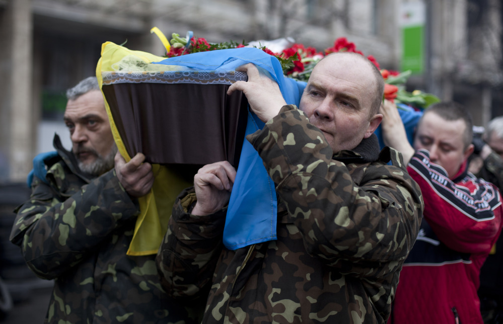 Pallbearers carry a coffin bearing the body Andryi Pozniak, 25, a self defense volunteer who was shot and killed by an unknown assailant two days ago near Kiev’s Independence Square, Ukraine, Thursday, March 6, 2014.