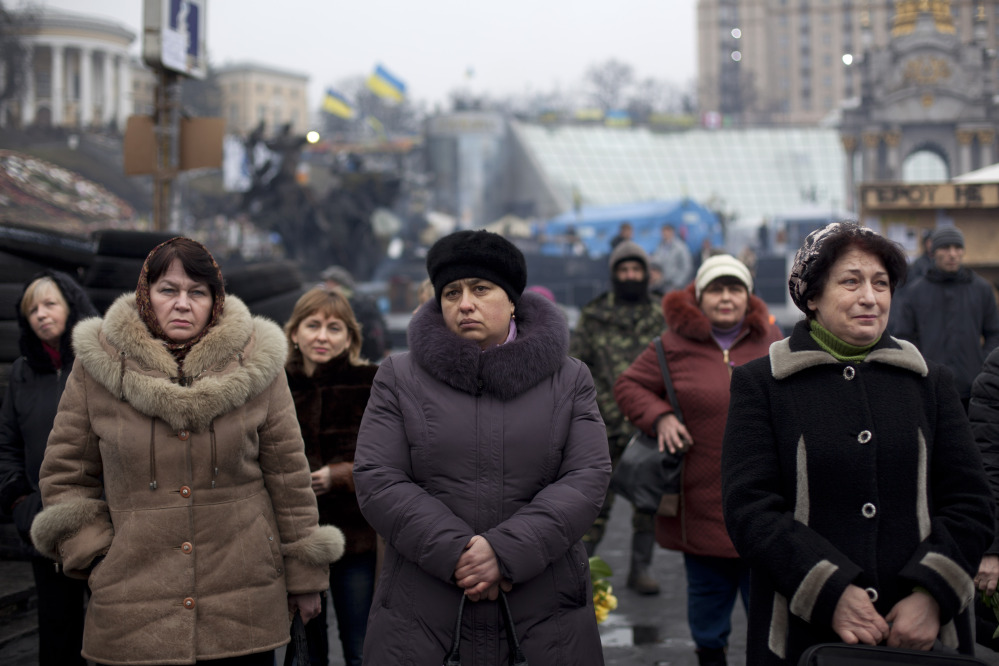 People attend a funeral ceremony for Andryi Pozniak, 25,a self defense volunteer who was shot and killed by an unknown assailant two days ago near Kiev’s Independence Square, Ukraine, Thursday, March 6, 2014.