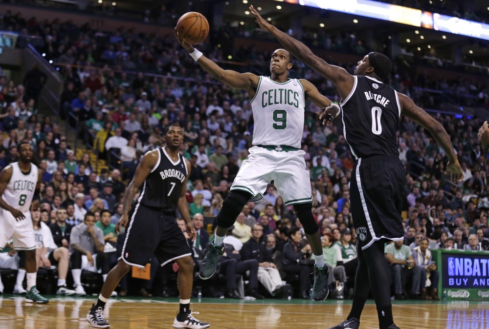 Celtics guard Rajon Rondo drives to the basket between Brooklyn’s Joe Johnson, left, and Andray Blatche during Boston’s 91-84 win Friday night