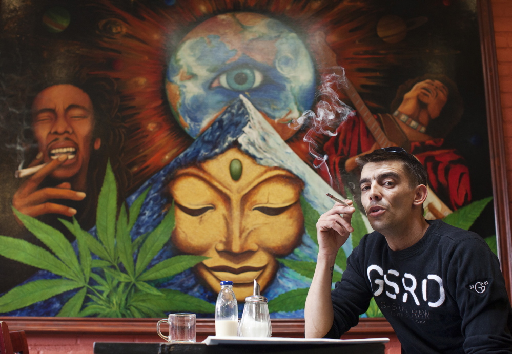 A man smokes a joint in a coffee shop in the Netherlands, the world pioneer in pot liberalization. The country has recently taken a harder line toward marijuana, with mixed results seen particularly in border towns.