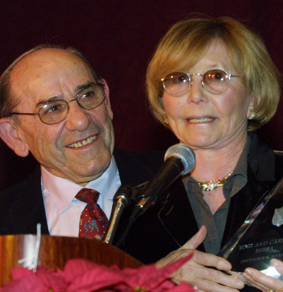 Baseball Hall-of-Famer Yogi Berra listens as his wife, Carmen, accepts the Pinnacle of Achievement award from the Salvation Army Association of Greater New York in 2000. She died Thursday at age 85.