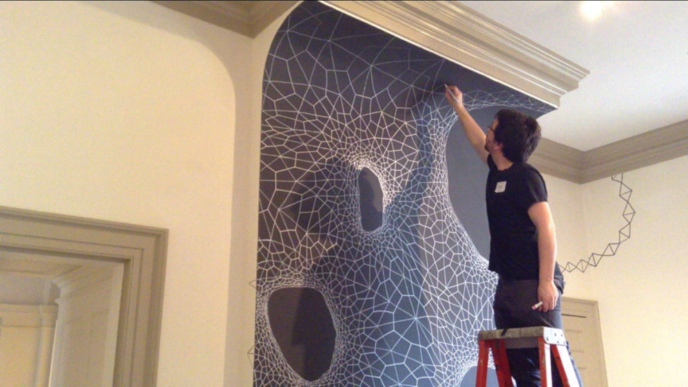 Clint Fulkerson works on the installation in the Portland Museum of Art’s Family Space.