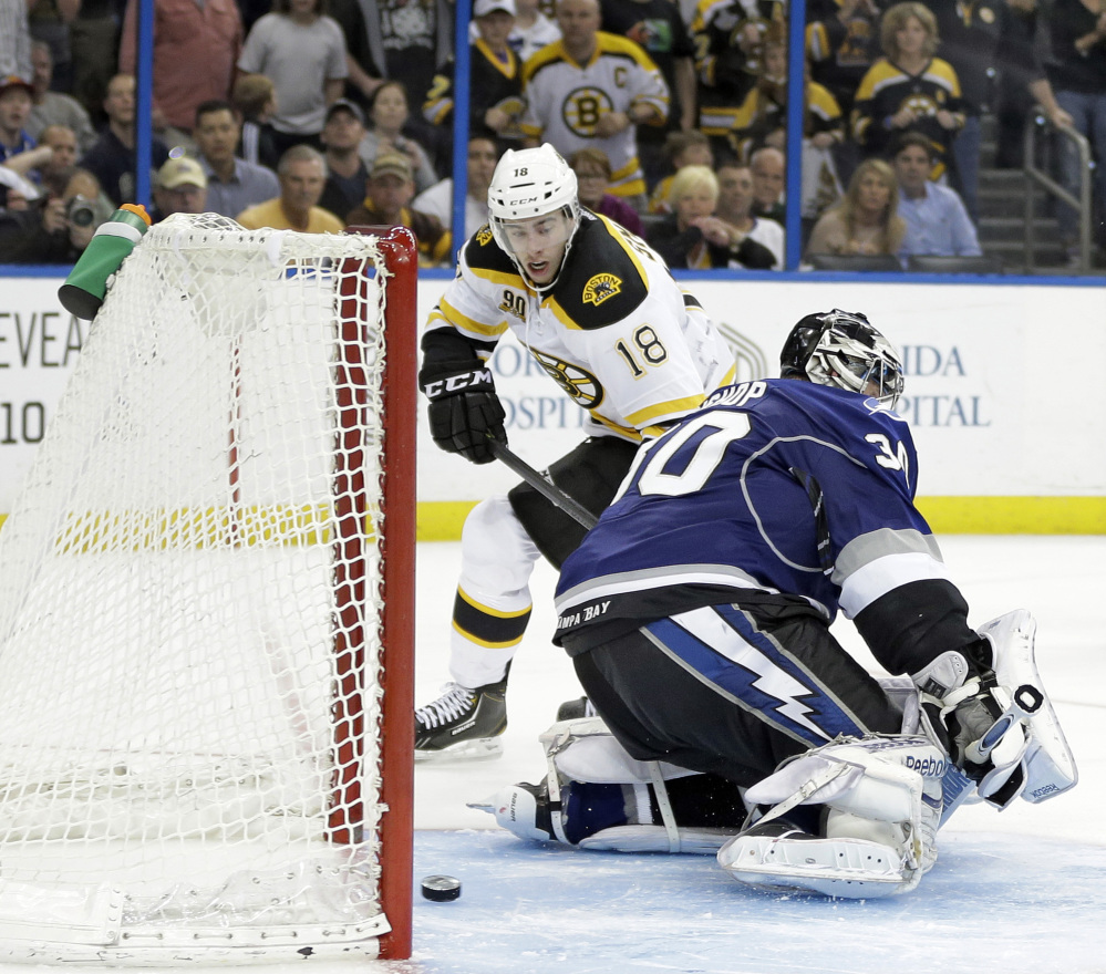 Boston’s Reilly Smith slips the puck under Tampa Bay goaltender Ben Bishop for the lone goal in Saturday’s shootout that resulted in a 4-3 victory for the Bruins.