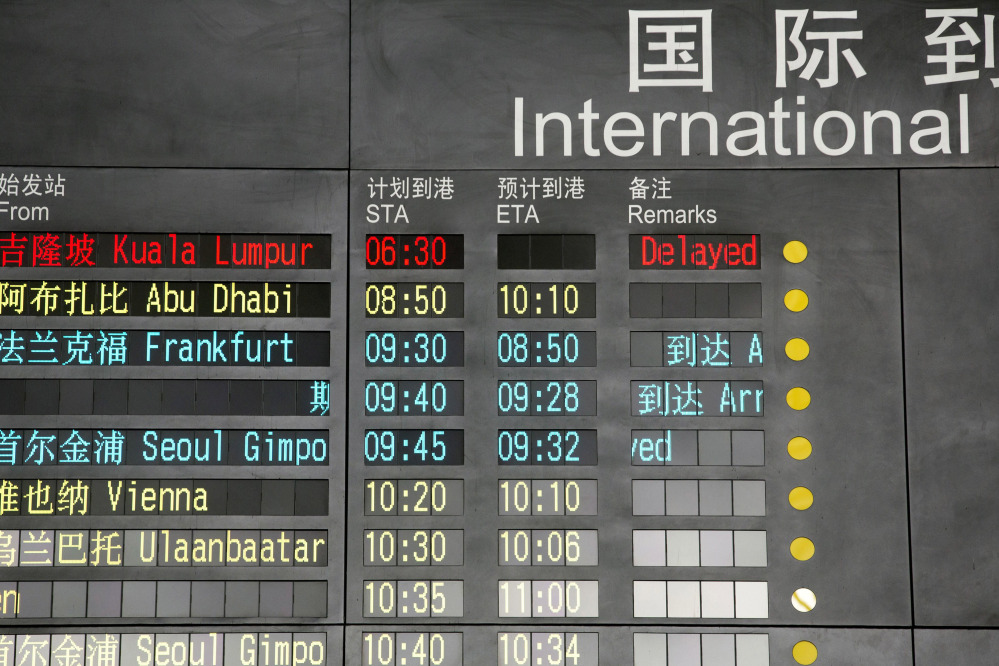 The arrival board at the International Airport in Beijing, China shows a Malaysian airliner is delayed, Saturday.
