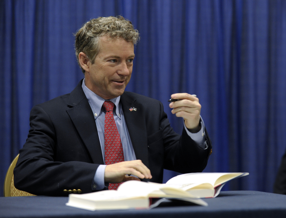 Sen. Rand Paul, R-Ky. signs copies of his book at the Conservative Political Action Committee annual conference in National Harbor, Md., Friday.