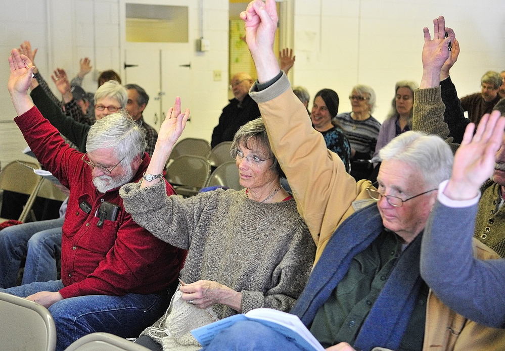 Peter Kallin, left, Sue Greenan and Dick Greenan vote from the front row Saturday during the Rome town meeting.