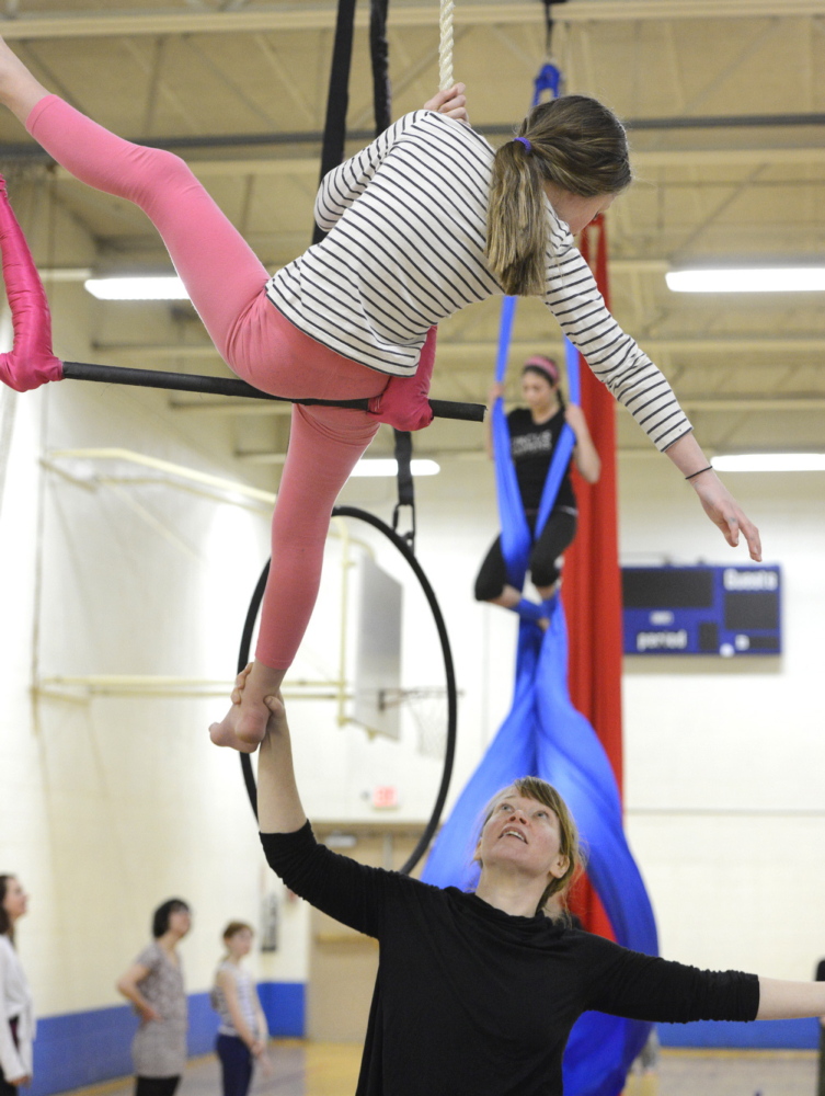 Aerials coach Jeanette Fertig works with Norah Peabey, 8, of Portland on the trapeze during Circus Atlantic’s open house at Reiche Community School in Portland on Saturday.