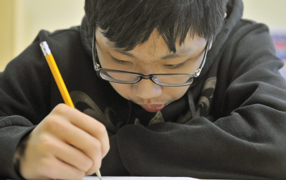 Eric Lu, 15, works through a mathematics problem Wednesday during Waterville Math Team practice at Waterville Senior High School. The team of mathletes has grown from six to 16 in about a year and a half.