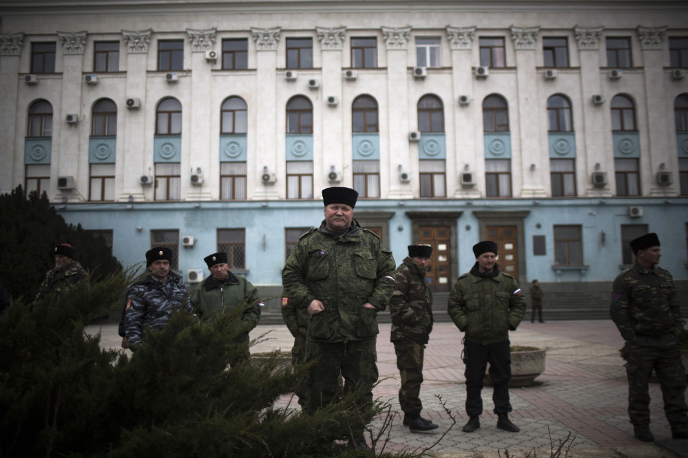 Cossacks and members of a voluntary self-defense force stand guard Saturday outside a government building in Lenin Square in Simferopol, Crimea, Ukraine.
