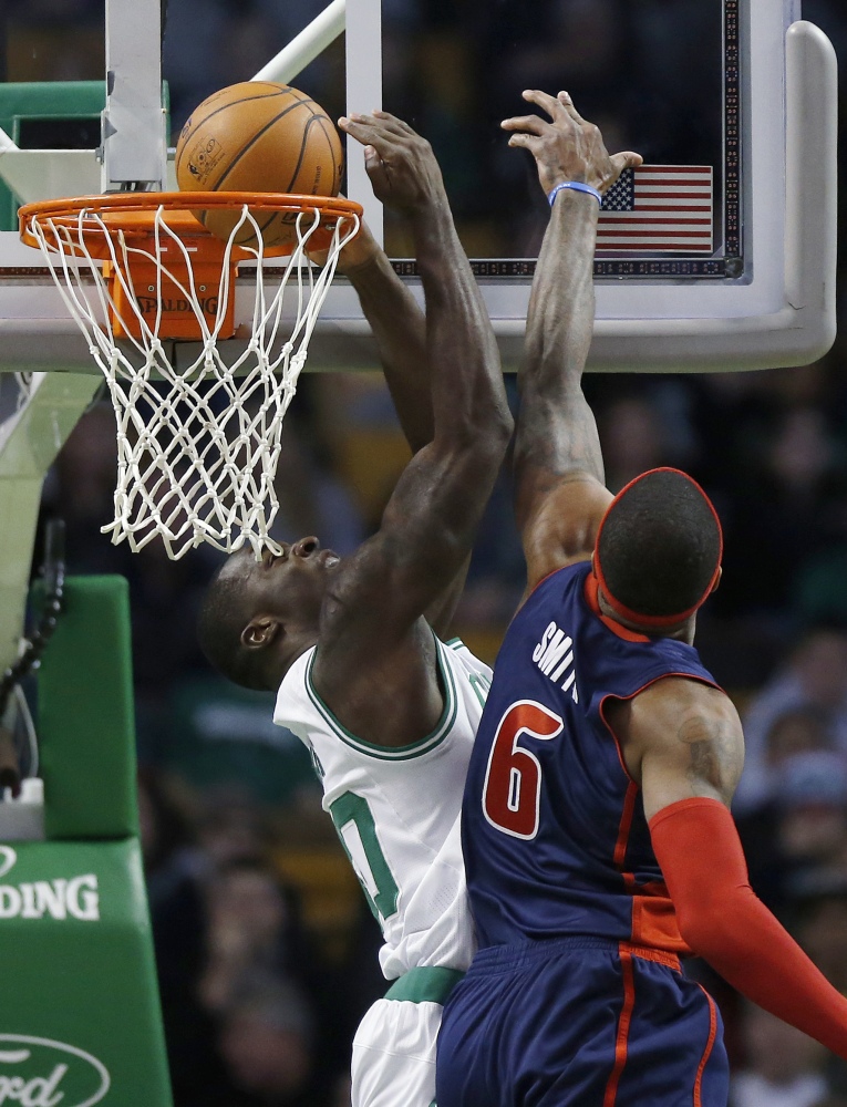 Boston’s Brandon Bass scores in front of Detroit’s Josh Smith in the first quarter of the Celtics' 118-111 win over the Pistons in Boston on Sunday.
