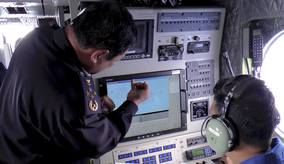 Adm. Mohd Amdan Kurish, left, of the Malaysian Maritime Enforcement Agency checks radar Sunday during a search for the missing Malaysia Airlines plane off Tok Bali Beach in Kelantan, Malaysia.