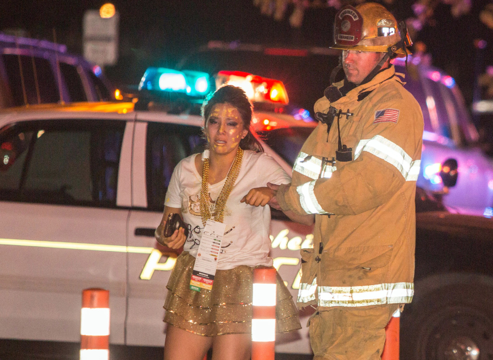 A firefighter assists an injured student after a stage collapsed during a student event at Servite High School in Anaheim, Calif., on Saturday. Authorities said 30-40 people were taken to hospitals with mainly minor injuries.