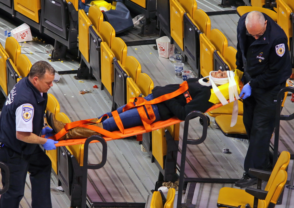 Emergency workers carry Sabina Grasso on a stretcher after a pole fell in TD Garden knocking Grasso unconscious.