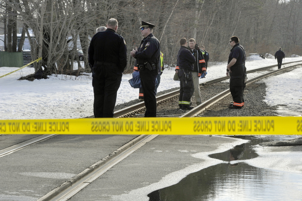 Old Orchard Beach police officers and firefighters and railroad police officers gather at the Union Avenue train crossing in Old Orchard Beach, where a man was struck and killed by a Downeaster on Tuesday afternoon in an apparent suicide.