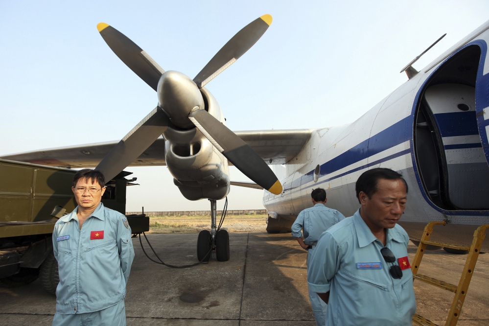 The crew of a Vietnam Air Force aircraft wait at a base Tuesday near Tan Son Nhat airport, Ho Chi Minh City, before a search operation for the missing Malaysian Airlines Boeing 777 over the seas between Malaysia and Vietnam Tuesday.