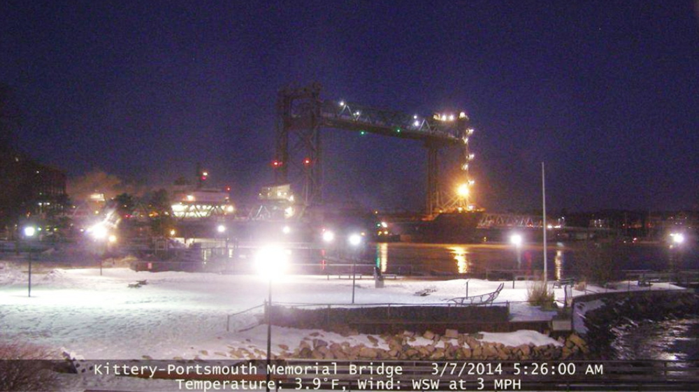This image provided by the New Hampshire Department of Transportation shows the Seapride – its bow visible beneath the yellow light to the right of center in the photo – resting against a pier of the Memorial Bridge at 5:26 a.m. last Friday.