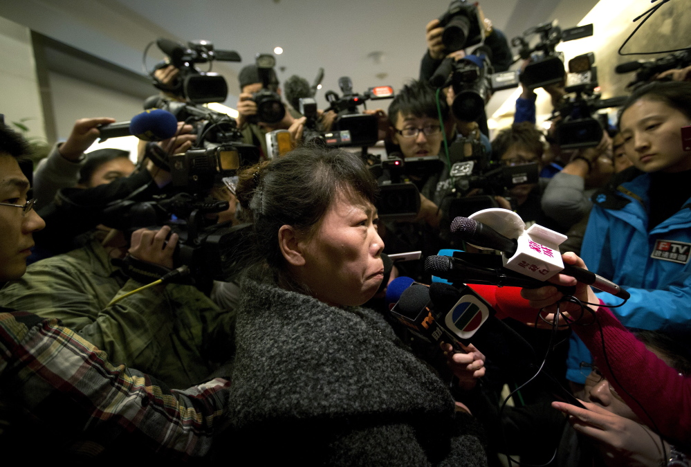A Chinese relative of passengers aboard a missing Malaysia Airlines plane is surrounded by media in Beijing as she answers questions about how families are being compensated.