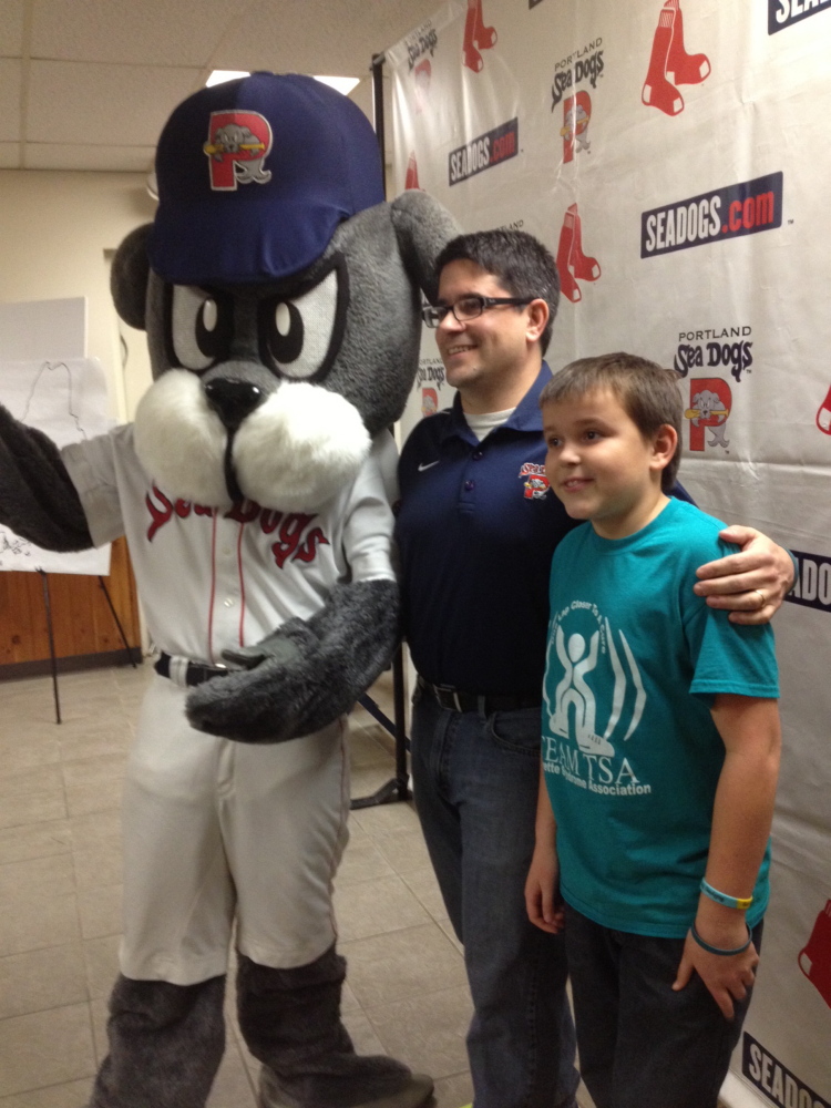 Justin LeBlanc, center, who animated Slugger for the first three years of the franchise’s existence in Portland, will walk with the Sea Dogs mascot from Fenway to Hadlock to raise funds for children with Tourette’s syndrome. At right is LeBlanc’s son Theo, who has Tourette’s.