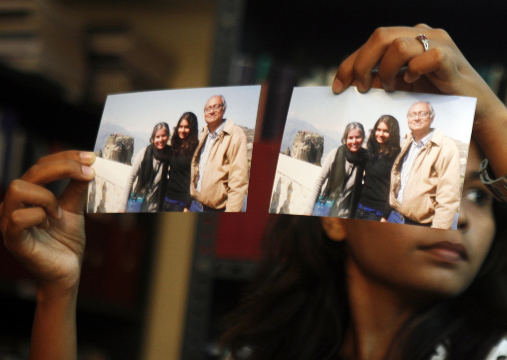 Photographs showing one of the passengers of the missing Malaysian Airlines aircraft Chandrika Sharma, left, her husband, Narendran, and daughter Meghna, are displayed during a news conference in Chennai, India, Wednesday. Narendran criticized the Indian government for its “silence” and said no government official has contacted the family about the incident, according to a local news agency.