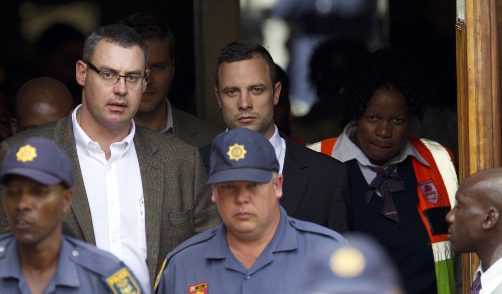 Oscar Pistorius, top center, leaves the high court in Pretoria, South Africa, Wednesday. He is charged with murder for the shooting death of his girlfriend, Reeva Steenkamp, on Valentines Day in 2013.