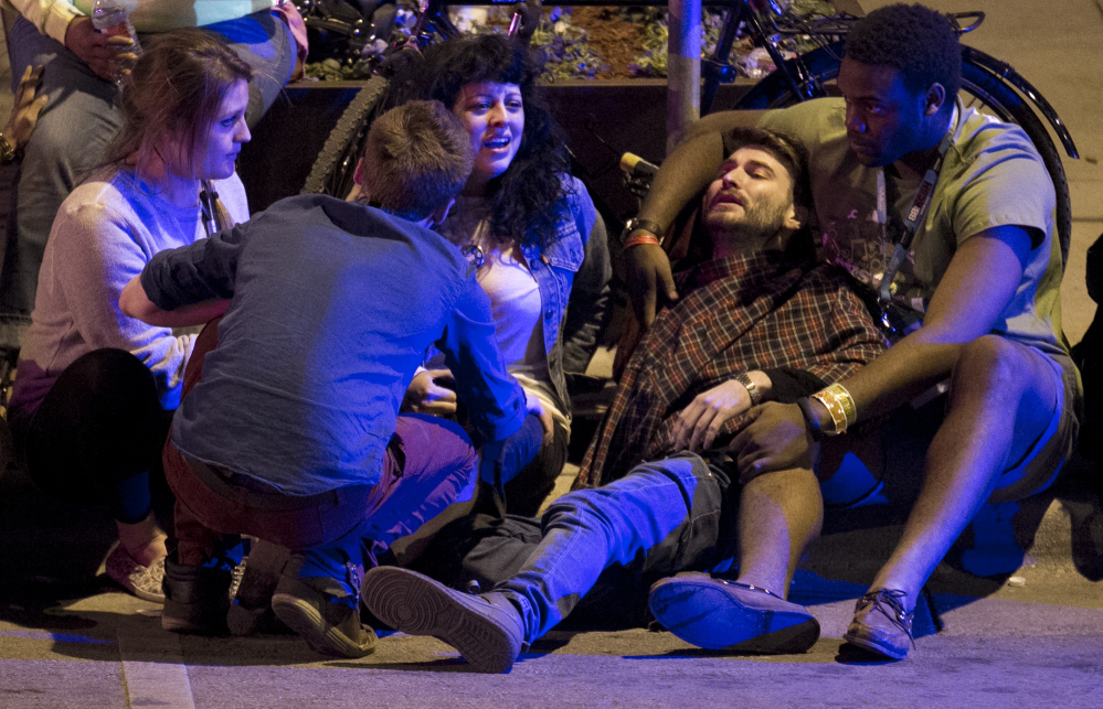 Unidentified people are comforted after being struck by a vehicle on Red River Street in downtown Austin, Texas, during SXSW late Wednesday.
