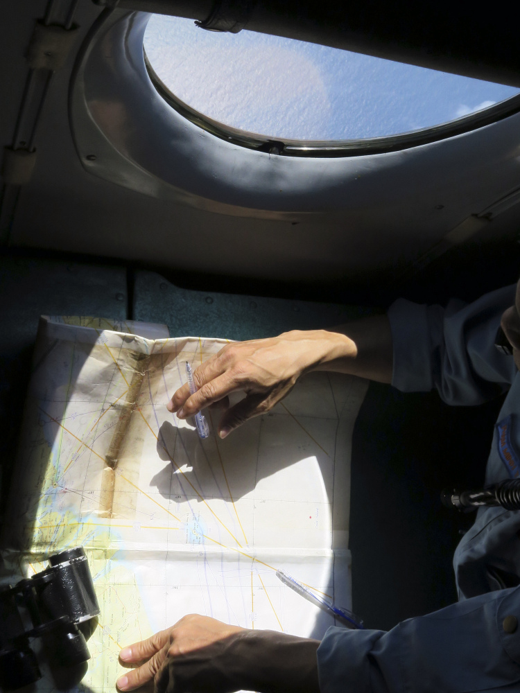 A Vietnamese Air Force crew member looks at a map during a mission Thursday over the Gulf of Thailand to search a location where Chinese satellite images showed possible debris from the missing Malaysia Airlines flight MH370.