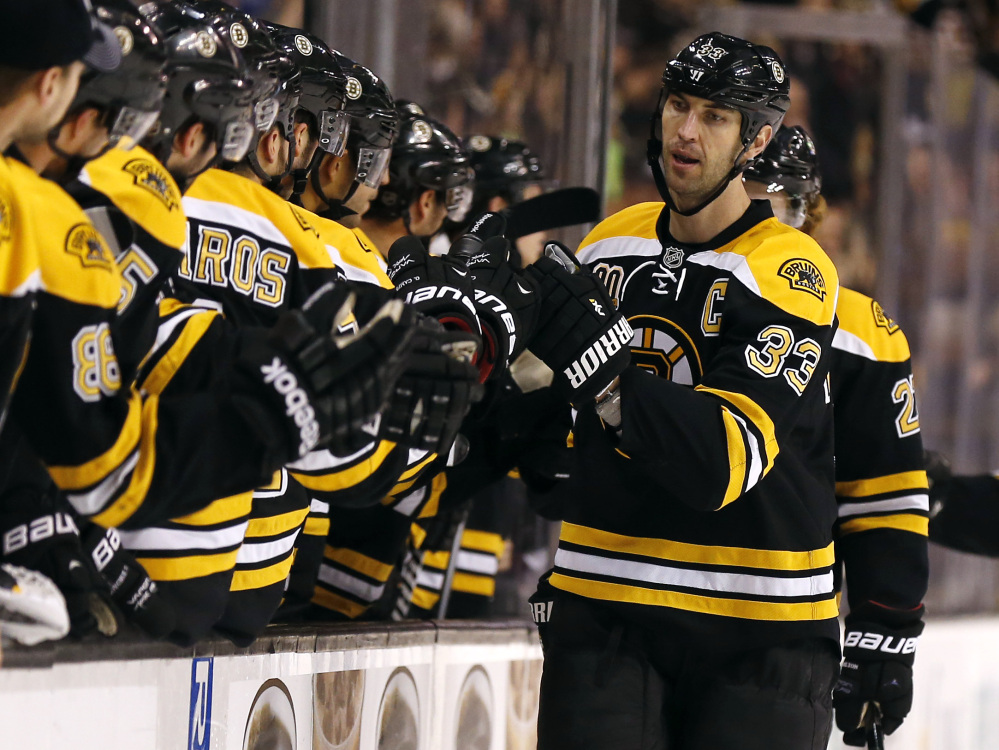 Boston Bruins defenseman Zdeno Chara is congratulated by teammates at the bench after scoring against the Phoenix Coyotes in the first period Thursday.