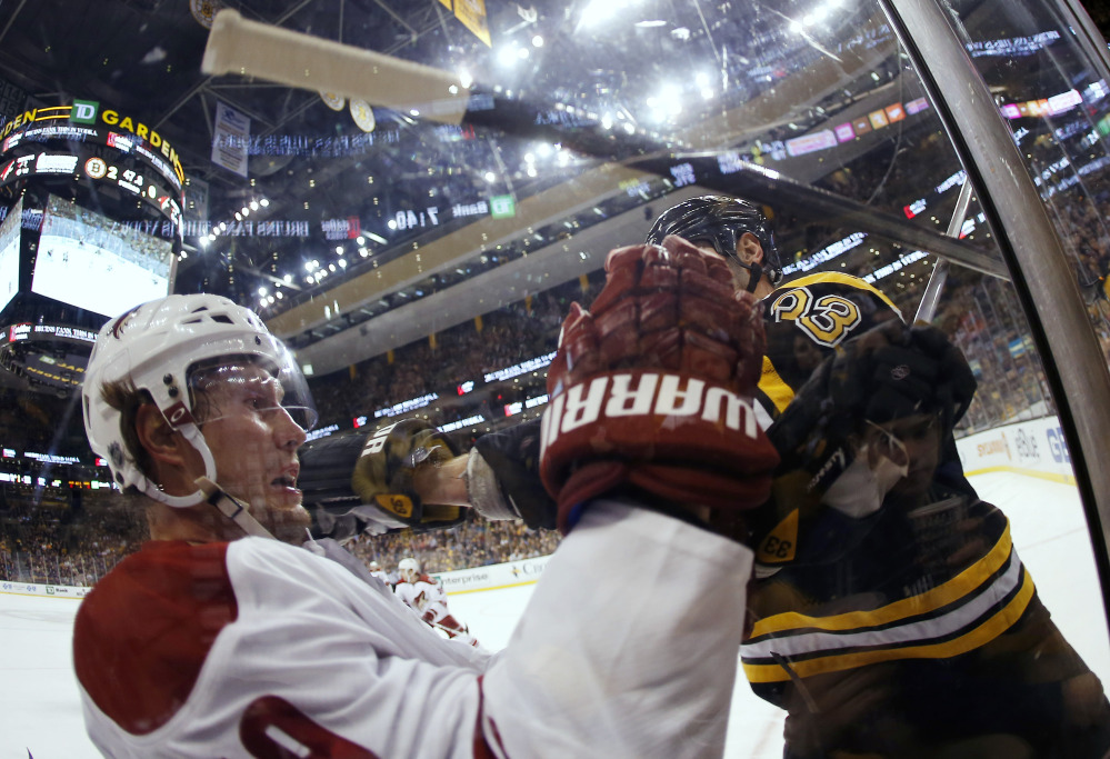 In this photo taken with a fish eye lens, Phoenix Coyotes’ Shane Doan loses his stick after being hit by Boston Bruins defenseman Zdeno Chara in the second period Thursday.