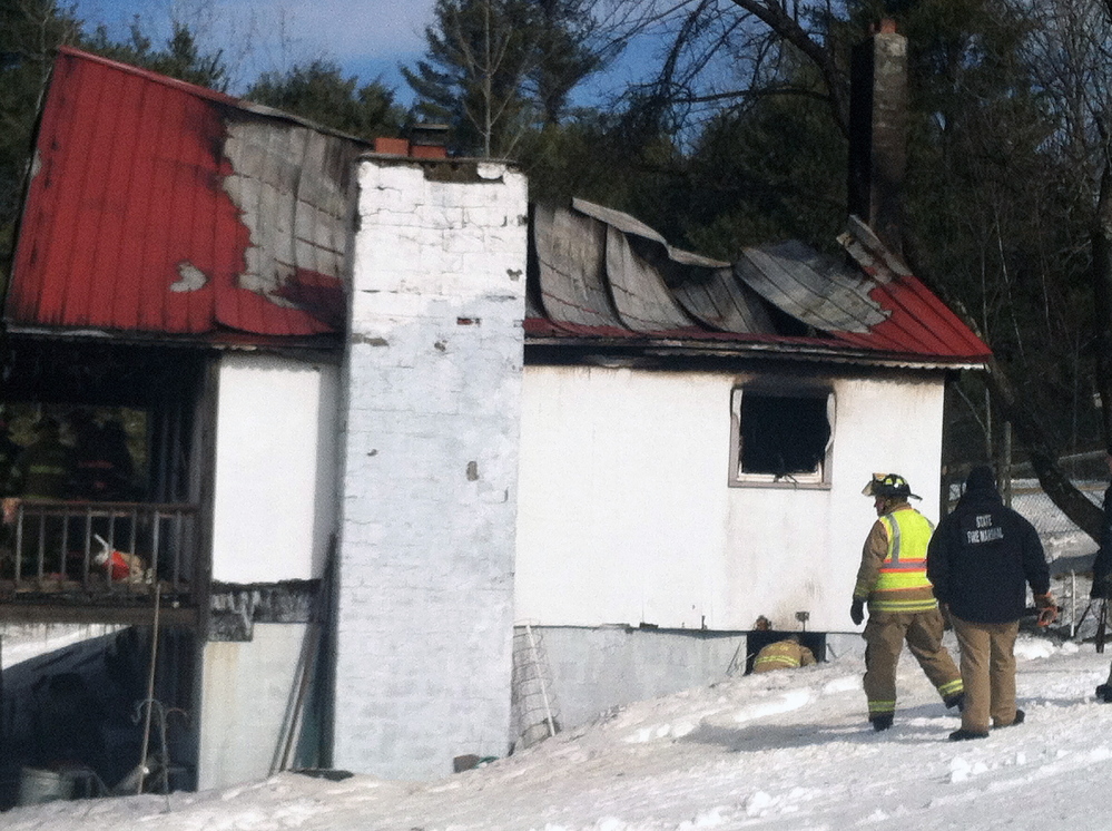 Firefighters inspect the scene after a fire destroyed this home at 1077 Hopper Road in Acton on Friday morning.