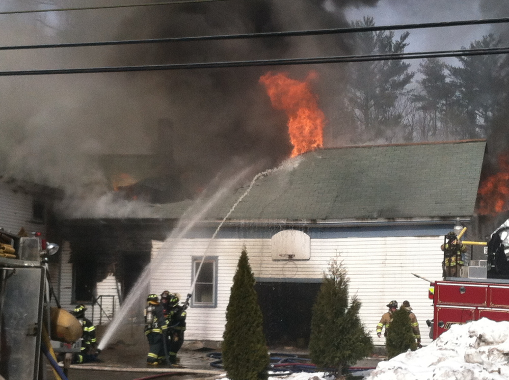 Firefighters battle a fire at a house on Route 111 in Arundel.