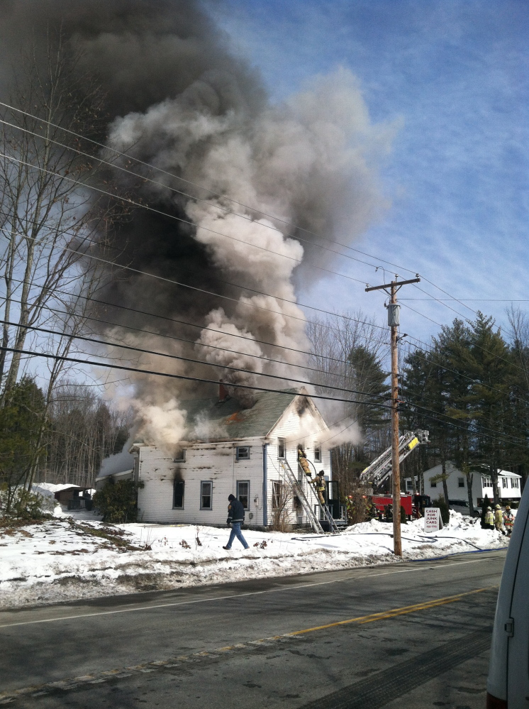 Firefighters battle a fire at 728 Alfred Road in Arundel across from Ledge Cliff Drive on Friday morning.