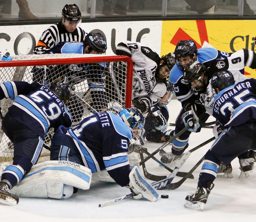 Maine goalie Martin Ouellette keeps the puck out of the net with help from his defense Friday night in Game 1 of the Hockey East quarterfinals at Providence, R.I. The Black Bears lost to Providence 3-1 and must beat the Friars two straight to avoid elimination.