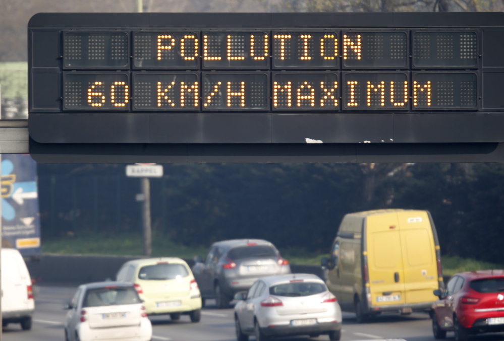 An electronic road sign reads “Pollution, speed limit 60 kms” on the Paris ring road Friday. Residents and visitors faced a dangerous dose of particles from smog.