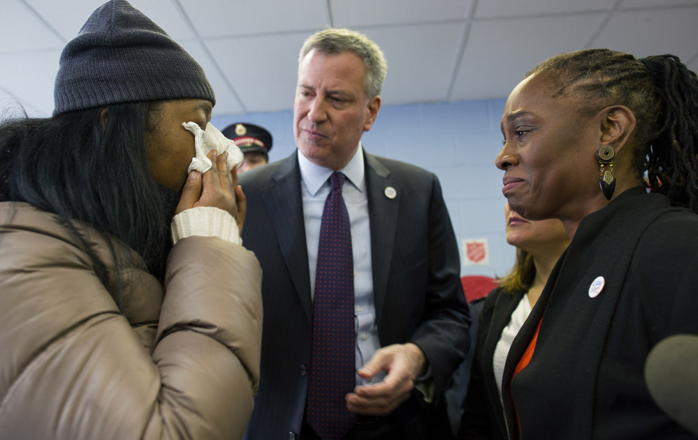 Aisha Watts, left, who was displaced after a gas explosion leveled two buildings in the East Harlem neighborhood of New York City on Wednesday, cries as she talks with New York City Mayor Bill de Blasio and his wife Chirlane McCray, at a Red Cross shelter being operated by the Salvation Army in New York on Friday.
