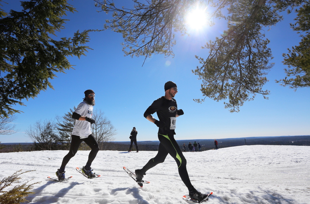 As the sun blazes their path, Trail Monsters Ian Parlin, right, and Tyler Lupien run along the summit of Bradbury Mountain State Park last Sunday.