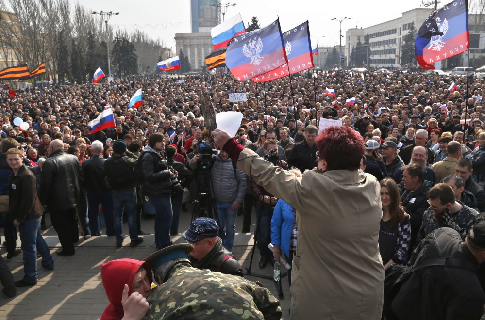 People shout slogans during a pro Russian rally at a central square in Donetsk, eastern Ukraine, on Saturday. Russian forces backed by helicopter gunships and armored vehicles Saturday took control of a village near the border with Crimea on the eve of a referendum on whether the region should seek annexation by Moscow, Ukrainian officials said.