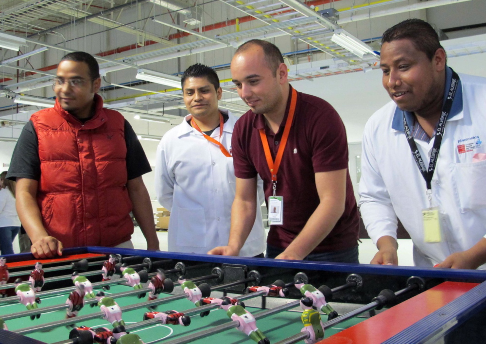 Employees on an afternoon break at the Plantronics headset assembly plant play foosball at tables set apart from assembly lines.