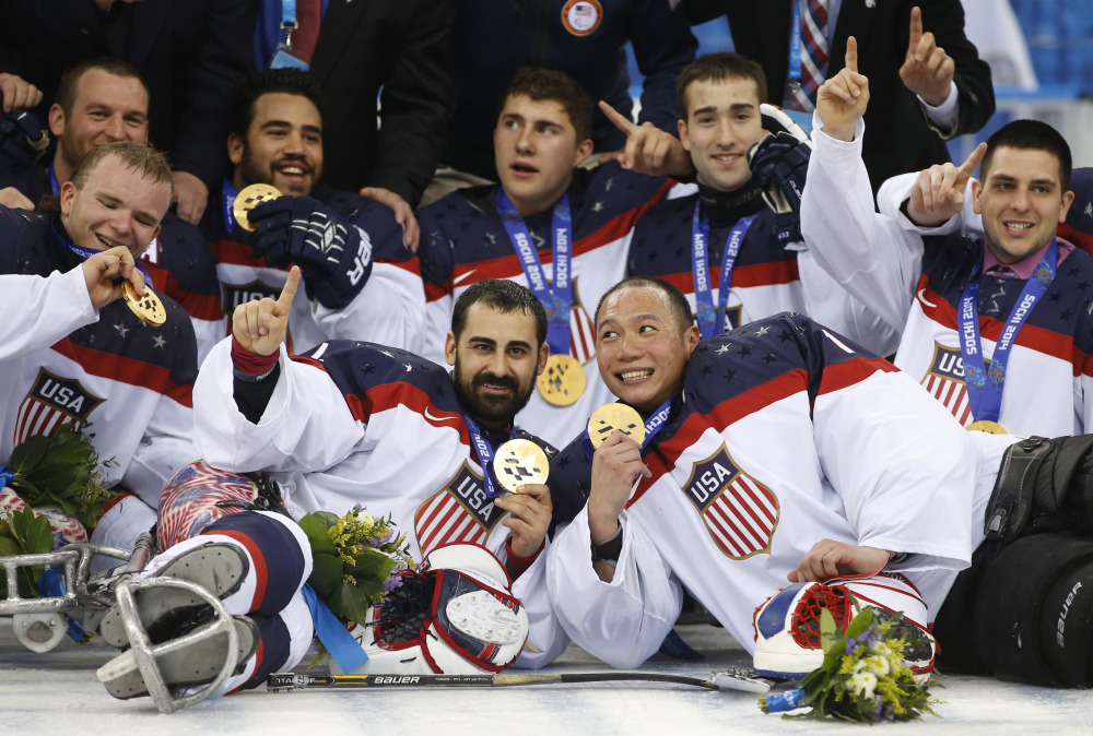 The Associated Press United States players pose for a team photo after winning the gold medal after their ice sledge hockey match against Russia at the 2014 Winter Paralympics in Sochi, Russia, on Saturday. The United States won 1-0 to defend its title.