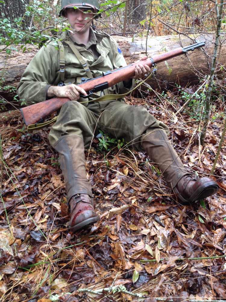 Re-enactor Justin Prejean plays a D-Day soldier preparing to tend to his wounded foot.