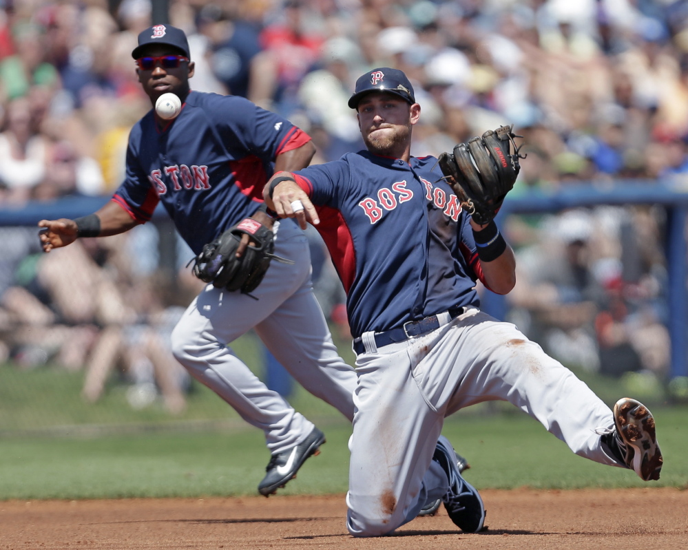 Boston third baseman Will Middlebrooks makes a throw in the first inning of an 8-4 exhibition loss to Tampa Bay at Port Charlotte, Fla., on Sunday. Backing up the play is Boston second baseman Jonathan Herrera.