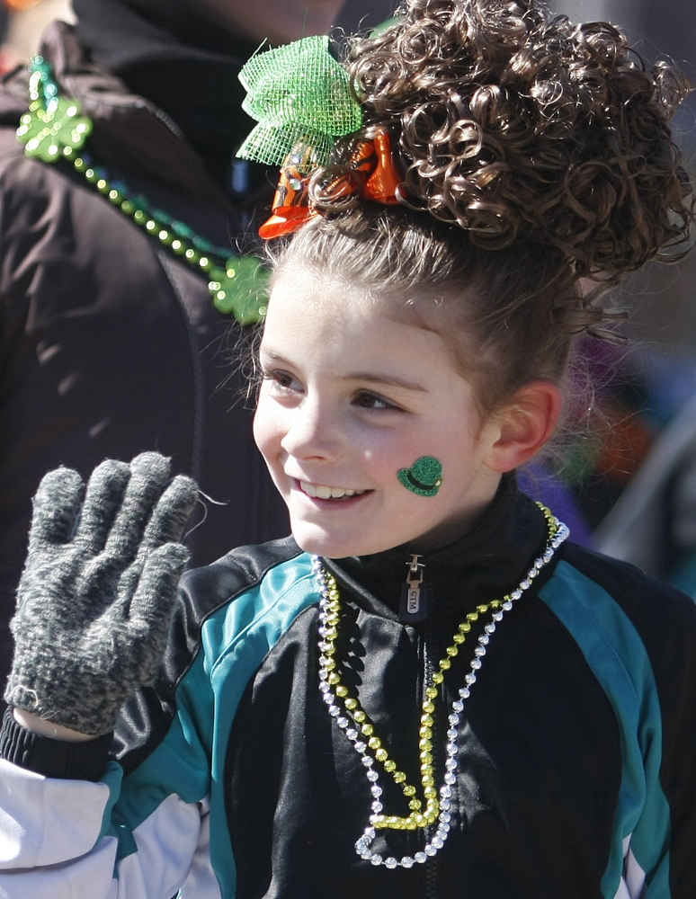Ava Williams, 7, waves hello to the crowd while performing with the Stillson School of Irish Dance.