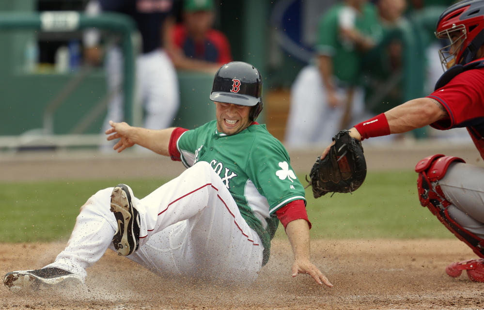 Daniel Nava of the Boston Red Sox evades the tag from St. Louis catcher Tony Cruz during a spring training game versus the St. Louis Cardinals in Fort Myers, Fla., Monday.