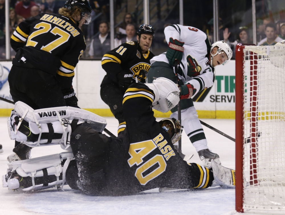 Boston Bruins goalie Tuukka Rask (40) drops to the ice to make a save on a shot by Minnesota Wild center Mikko Koivu (9) during the first period of an NHL hockey game, Monday, March 17, 2014, in Boston. (AP Photo/Charles Krupa)