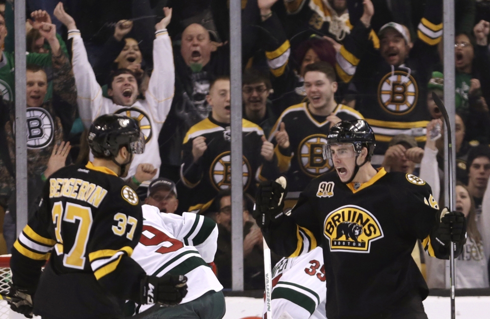Boston Bruins fans celebrate with right wing Reilly Smith, right, after his goal during the third period of an NHL hockey game against the Minnesota Wild, Monday, March 17, 2014, in Boston. The Bruins defeated the Wild 4-1. (AP Photo/Charles Krupa)