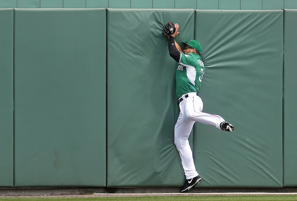 Boston Red Sox outfielder Grady Sizemore slams into the center field wall but holds on to make the catch during a spring training game versus the St. Louis Cardinals on Monday.